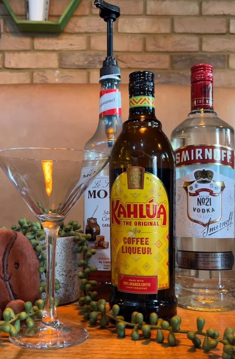 Kahlúa, vodka and vermouth on the bar with a chilled martini glass